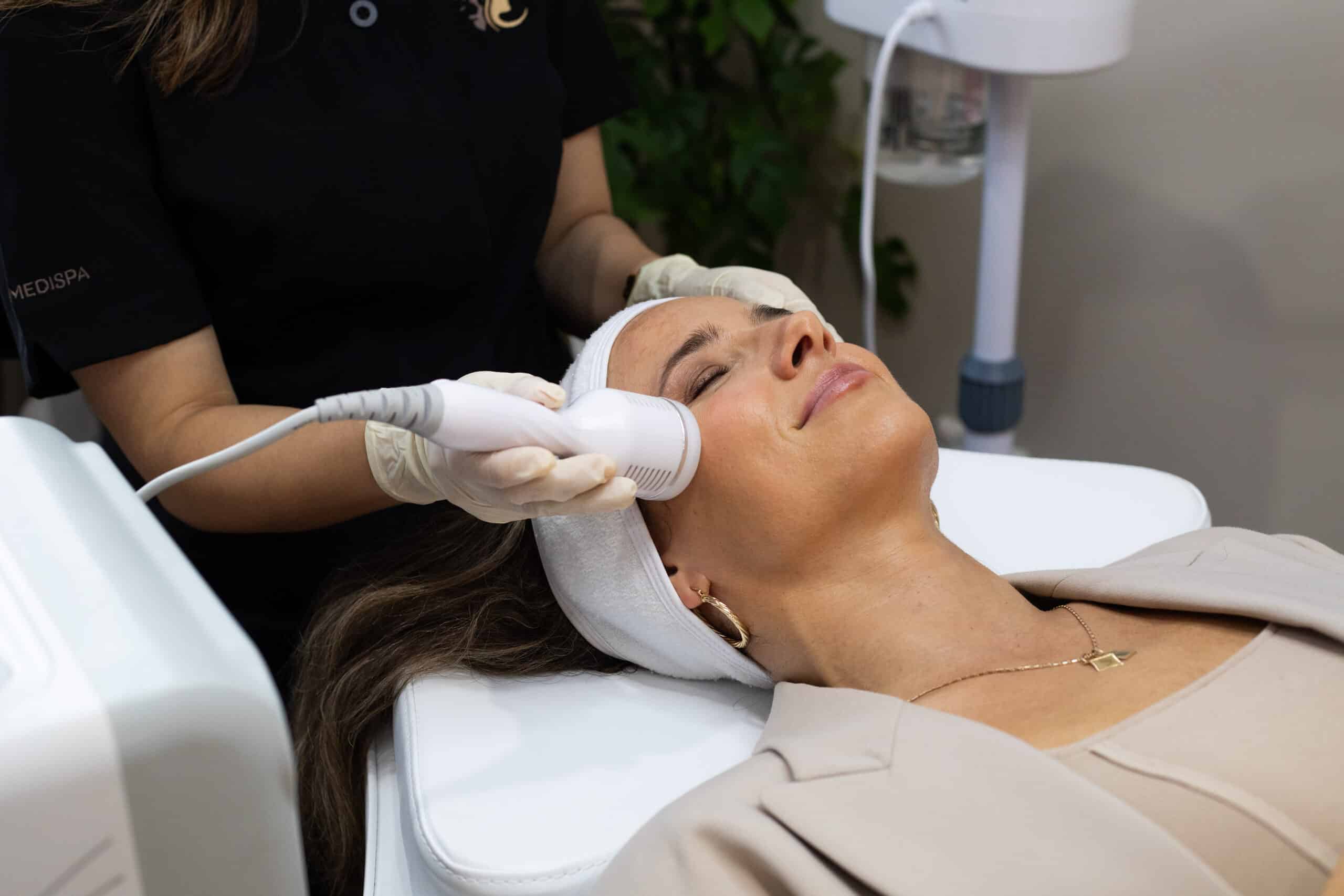 Clinician performing a professional facial treatment with a handheld device on a relaxed client at Jay’s Medispa Birkenhead Auckland.